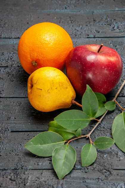 农产品正面是新鲜水果苹果梨和橘子 背景是深色水果 新鲜成熟 醇厚水果苹果柠檬