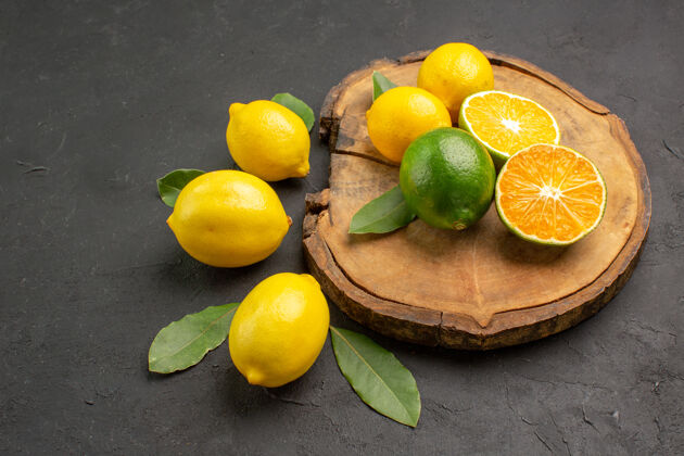 营养前视图新鲜的酸柠檬和树叶在黑暗的背景食物健康深色