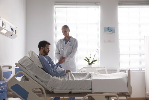 女人生病的男病人在床上和护士说话诊所医疗健康