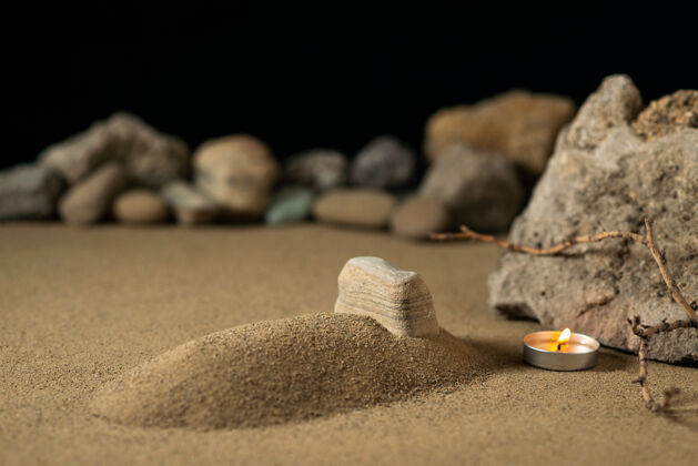 战争小坟上用蜡烛和石头在沙滩上举行葬礼大战土壤鹅卵石自然