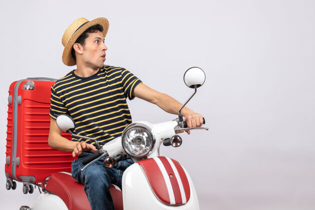 摩托车一个戴着草帽的好奇的年轻人正盯着什么东西稻草传送带轻便摩托车