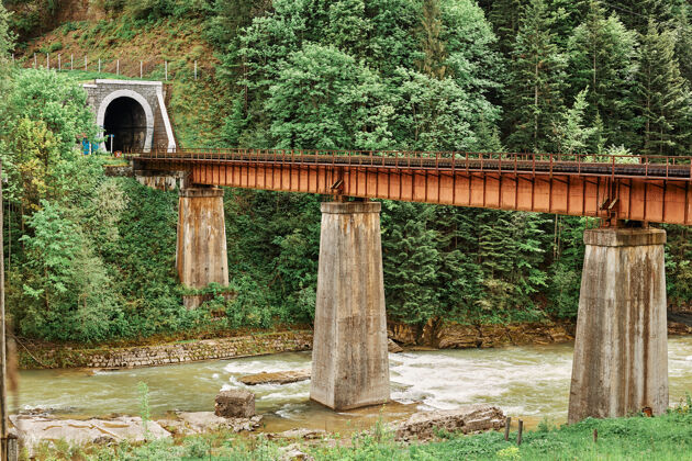 机架山河上的旧火车轨通向隧道乡村峡谷桥