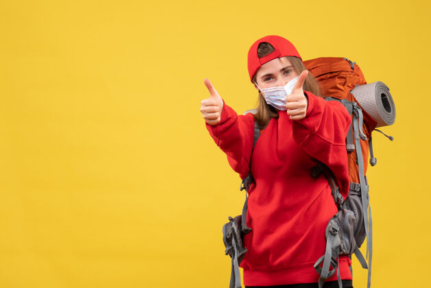 赠送正面图年轻游客带着旅游背包和面具竖起大拇指背包面具拇指