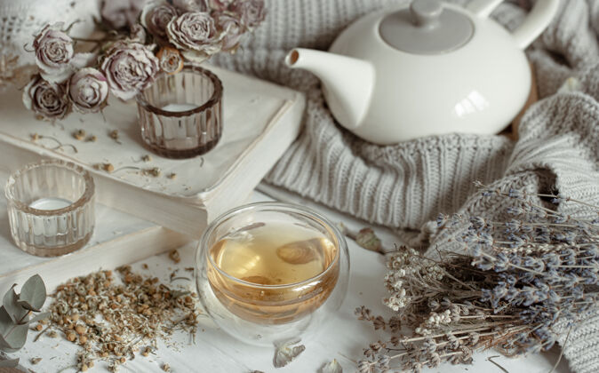 床用蜡烛 一杯茶 一个茶壶和干草来营造温馨的静物生活灯芳香构图