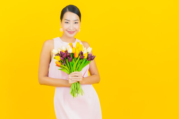 花肖像美丽的亚洲年轻女子微笑与黄色的花女士黄色花束