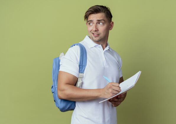 绿色看着身边印象深刻的年轻帅气男生背着书包拿着笔记本拿着笔年轻手持笔记本