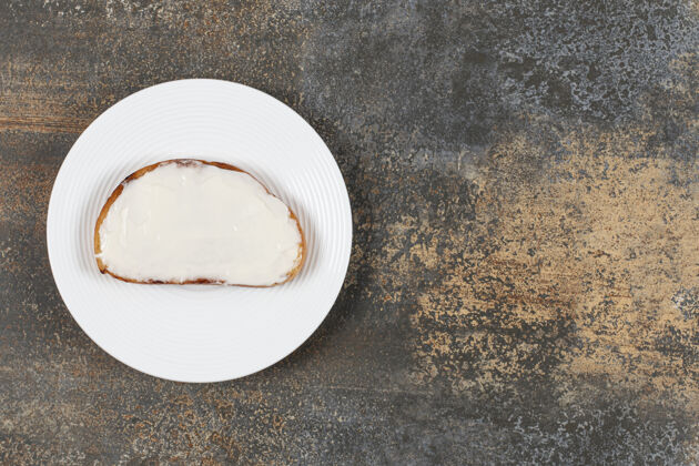 面包在白色盘子上放一片带酸奶油的烤面包片食物奶油酸奶油