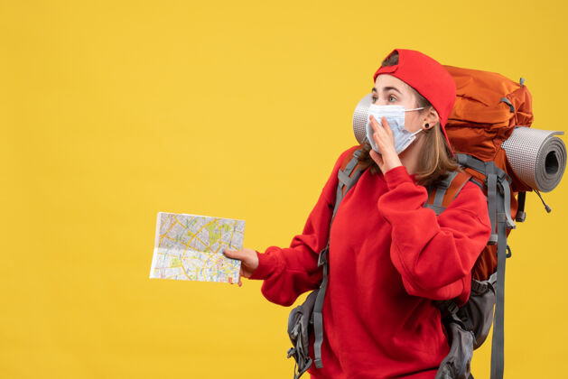 地图正面图年轻女游客背着背包和面具拿着旅游地图背包包面具