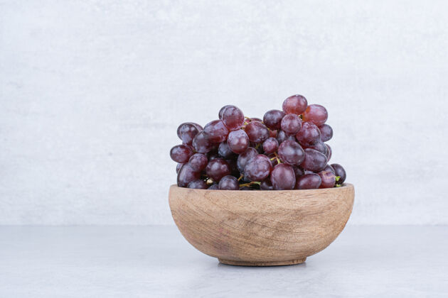 葡萄一个装满紫色葡萄的木碗在白色的上面好吃好吃碗