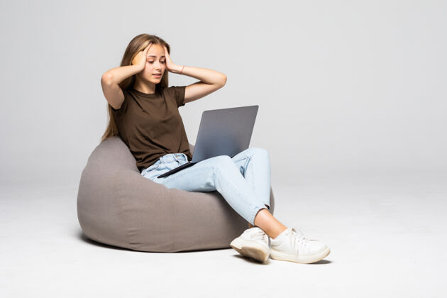 女人沮丧和沮丧的女人用笔记本电脑工作绝望的工作隔离在白墙上沮丧悲伤沮丧人