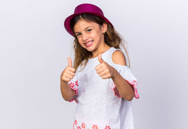 帽子微笑着戴着紫色派对帽的小白种女孩竖起大拇指孤立地站在白色墙壁上 留着复制空间微笑白种人孤立