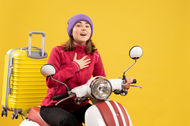 休闲正面图：穿着便服 骑着轻便摩托车的年轻女旅行者衣服前面摩托车