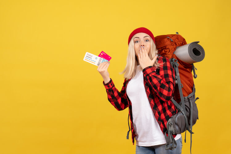 抱着正面图是一个金发女孩 背着背包 手里拿着名片和旅行票欢呼前面微笑