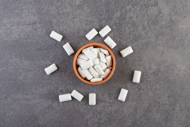 糖放满白色口香糖的泥碗放在石桌上美味食物白色