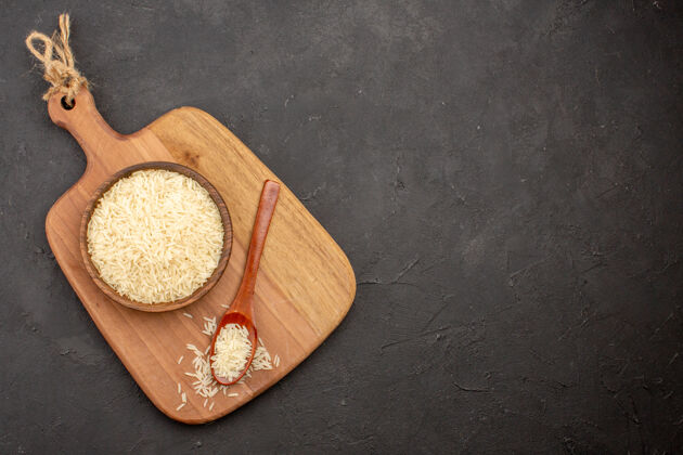 盘子灰色表面上棕色木板内生大米的俯视图食物烹饪健康