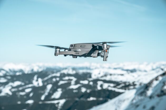 白色特写镜头的无人驾驶飞机在一个美丽的山区景观覆盖着雪风景冬天自然