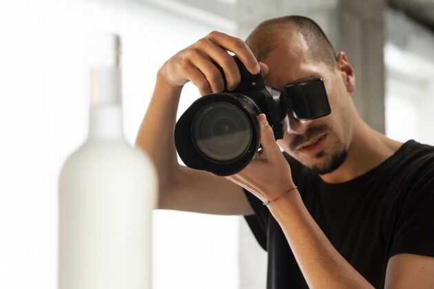 镜头男产品摄影师在工作室工作职业摄影师数码相机