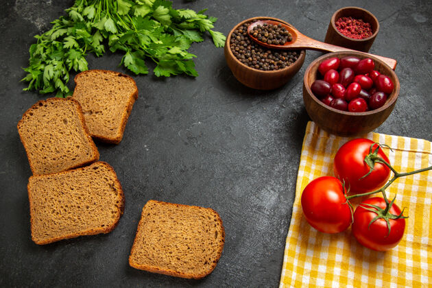 番茄新鲜的红色山茱萸的顶视图 灰色的表面上有黑色的面包 绿色的面包和西红柿食物面包深色