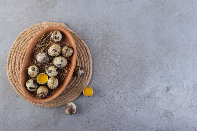 生石桌上摆满了生鹌鹑蛋的棕色盘子鹌鹑新鲜蛋白质