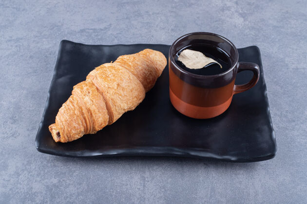 咖啡馆牛角面包配咖啡法式牛角面包放在盘子和一杯浓咖啡上木头平铺黑暗