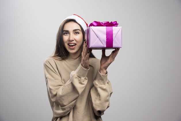 女孩微笑的女人拿着一盒圣诞礼物圣诞老人圣诞节年轻