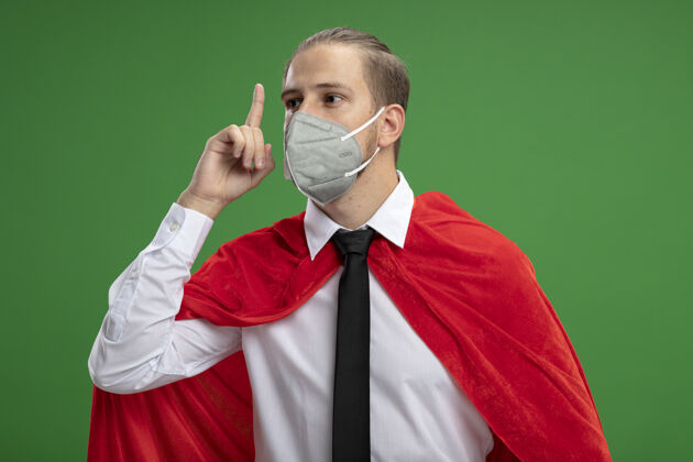 医疗年轻的超级英雄戴着医用面罩 打着领带 指着绿色的天空面具穿超级英雄