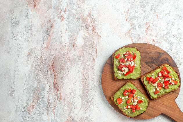 食物美味的鳄梨三明治的俯视图 白色表面上有切成薄片的红色西红柿午餐切片西红柿