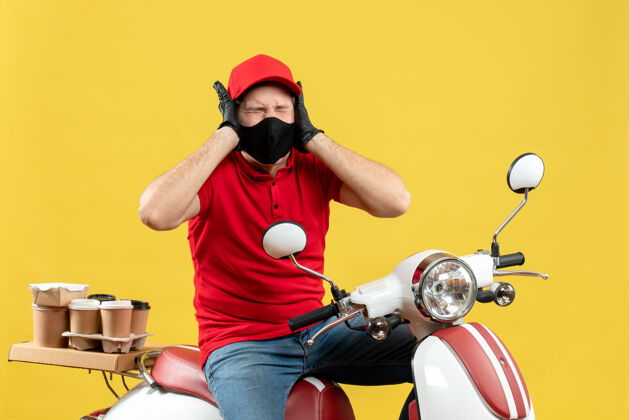 命令俯视图：紧张的年轻人穿着红色上衣 戴着帽子手套 戴着医用面罩 坐在滑板车上传递命令 情绪激动男子车辆摩托车