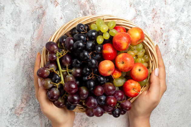 水果白色表面上篮子内新鲜葡萄的俯视图健康葡萄浆果