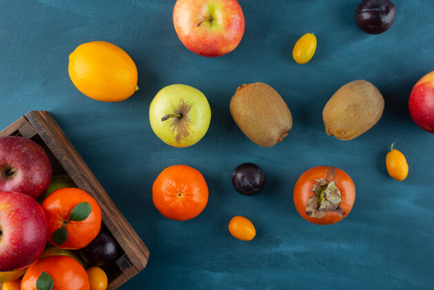 新鲜一堆新鲜的水果放在蓝色的表面上熟的生的苹果