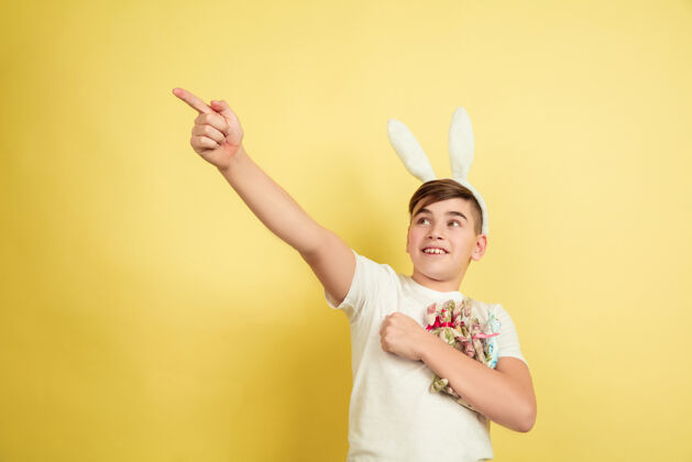 光明复活节兔子男孩与明亮的情感黄色工作室墙上青少年趋势帅气