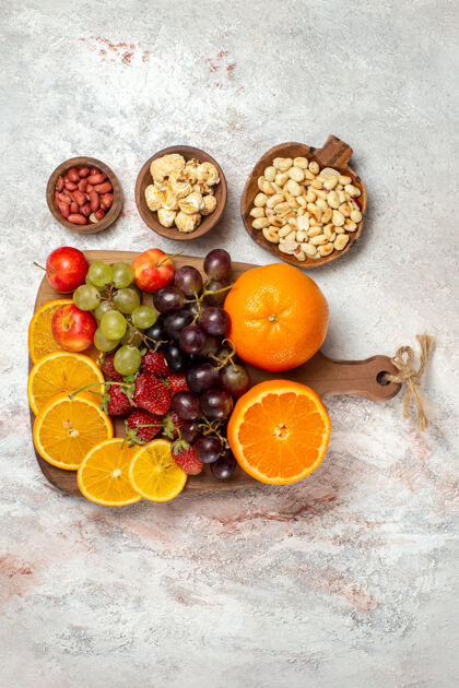 新鲜水果组成新鲜水果组成的顶视图新鲜橙子葡萄坚果和草莓在白色表面草莓食品柑橘