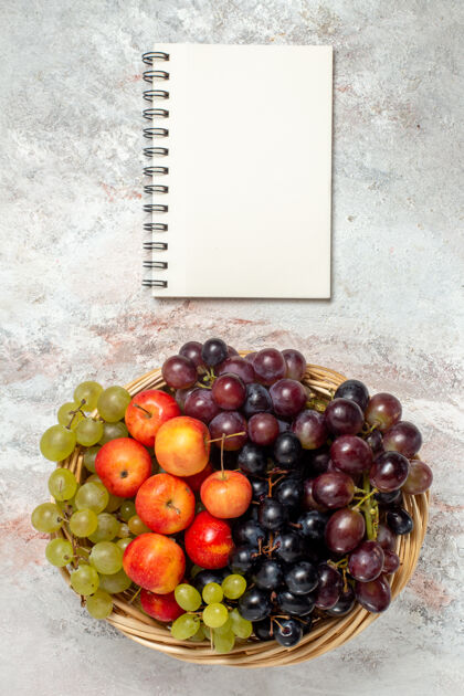 新鲜葡萄白色表面上有李子的新鲜葡萄俯视图饮食多汁成熟