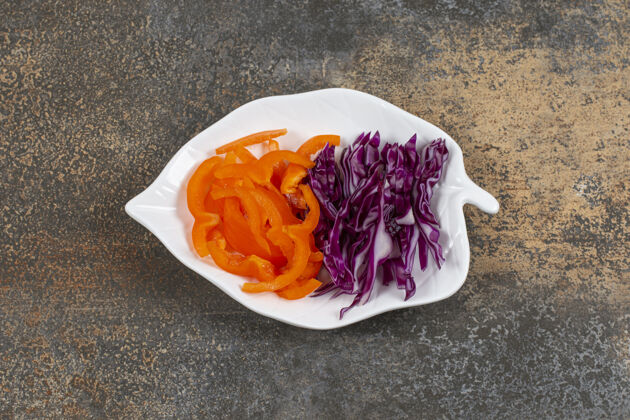 蔬菜白盘子上的紫白菜丝和胡椒粉烹饪装饰新鲜