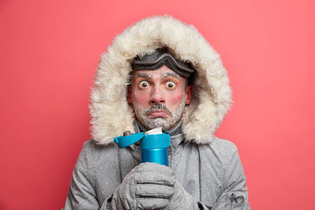 男性一张震惊尴尬的照片 一个因寒冷而发抖的男人在寒冷的天气里花了很多时间在户外喝热茶 拿着保温瓶 穿着冬季运动服女性惊艳冬季
