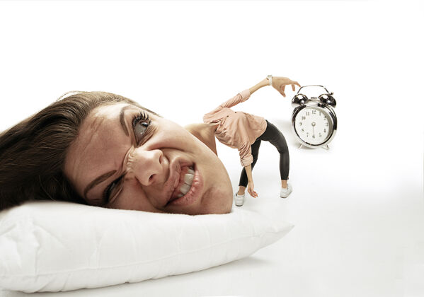 交易讨厌这个闹钟的声音大脑袋放在小身体上躺在枕头上女人醒不过来 因为头痛 生气和睡过头工作 工作 匆忙的概念 时间限制合同忙紧张