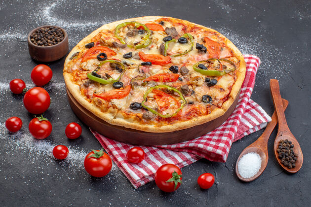 食物正面是美味的奶酪披萨 黑色的表面有红色的西红柿西红柿晚餐汉堡