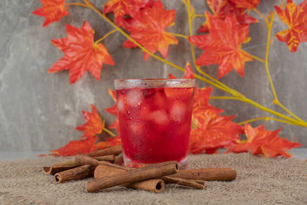 营养一杯果汁 配水果片 树叶和肉桂条 放在粗麻布上水果叶子美味