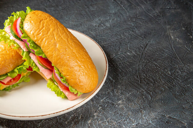 健康美味的自制三明治的俯视图在一个白色的盘子上黑色的苦恼的表面三明治自制三明治美味