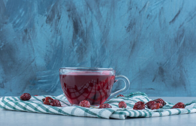 配料玫瑰果和茶放在大理石毛巾上玫瑰果毛巾美味