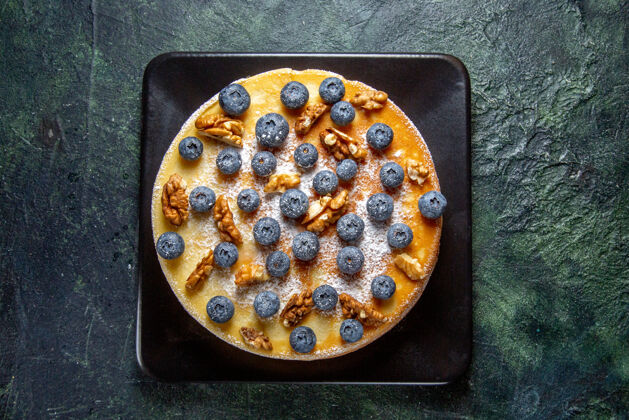 甜点顶视图美味的蜂蜜蛋糕与蓝莓和核桃内板黑暗的表面盘子水平蓝莓