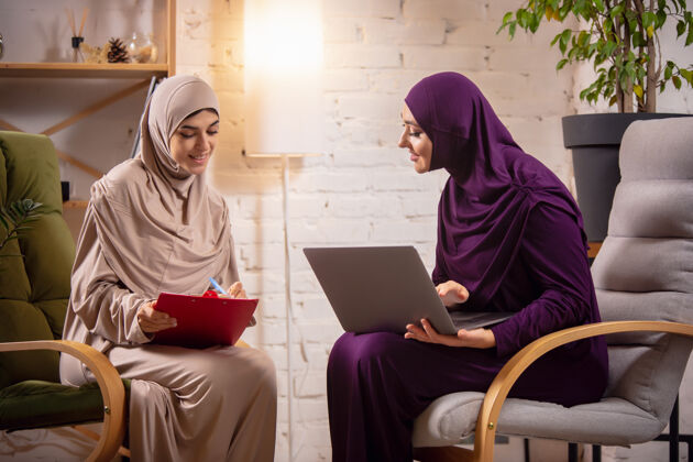 模型快乐的两位妇女在家上课 在电脑旁学习 在线教育伊斯兰计算机房子