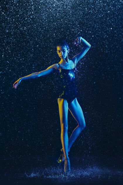 明亮年轻的女芭蕾舞演员在水滴和浪花下表演白种人模特在霓虹灯下跳舞迷人的女人芭蕾舞和当代舞蹈概念创意艺术照片舞蹈灵活舞蹈
