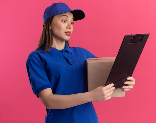 印象穿着制服的漂亮女送货员拿着名片盒 看着粉色的剪贴板名片盒剪贴板制服