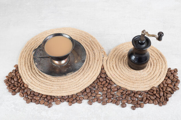 美味咖啡豆和咖啡研磨机在大理石表面营养烤咖啡