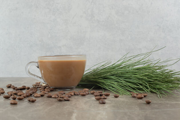 热咖啡 松草和咖啡豆放在大理石桌上食物热的浓缩咖啡