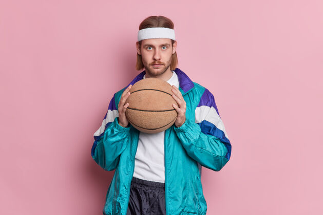 球严肃的蓝眼睛 留着胡茬长发的男篮手拿着球准备打比赛 戴着白色的头带和运动服帅气持有游戏