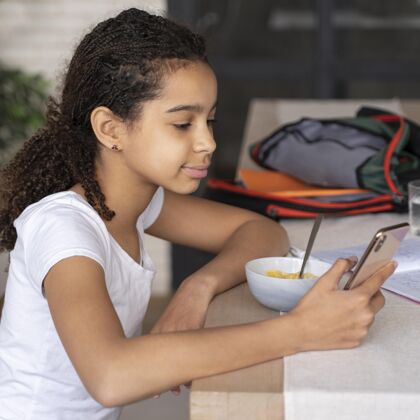 女孩吃早饭的时候看手机的女孩准备好年轻教育