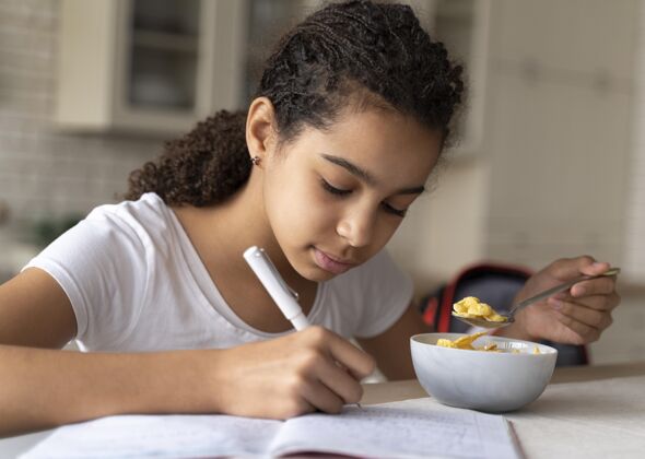 学习吃早饭时做作业的女孩室内年轻准备好