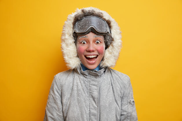 乐观人们的生活方式和冬季活动观念开朗的黑皮肤女人笑容满面站满幸福穿着冬衣和滑雪镜时尚请冬季